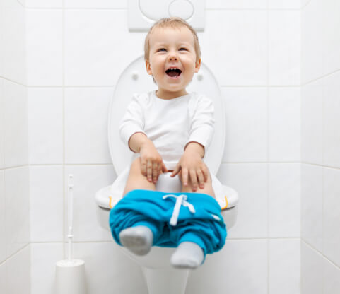 a cute little boy on the commode