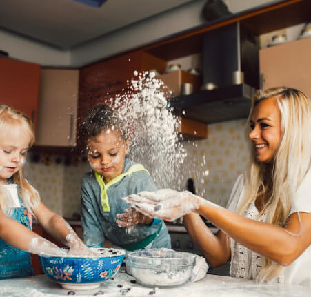 a woman enjoying baking with two kids